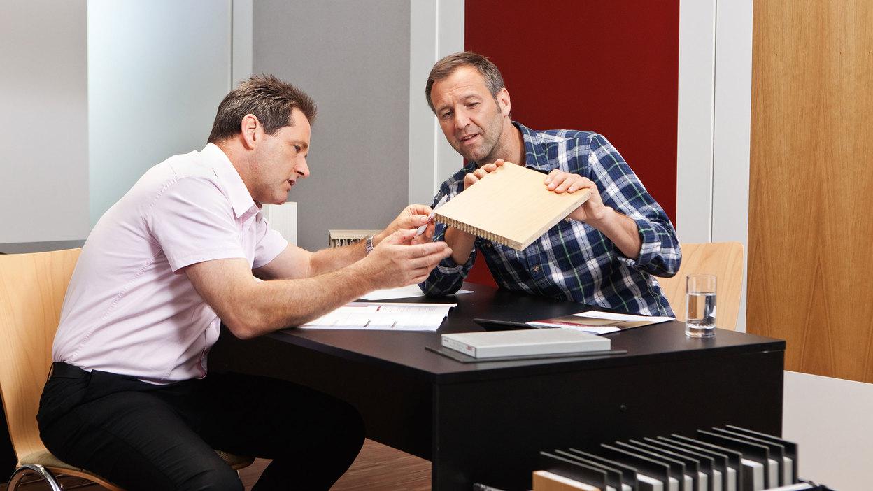 Detailberatung zu verschiedenen Holzmaterialien Detailberatung zu verschiedenen Holzmaterialien zwischen zwei Männern.