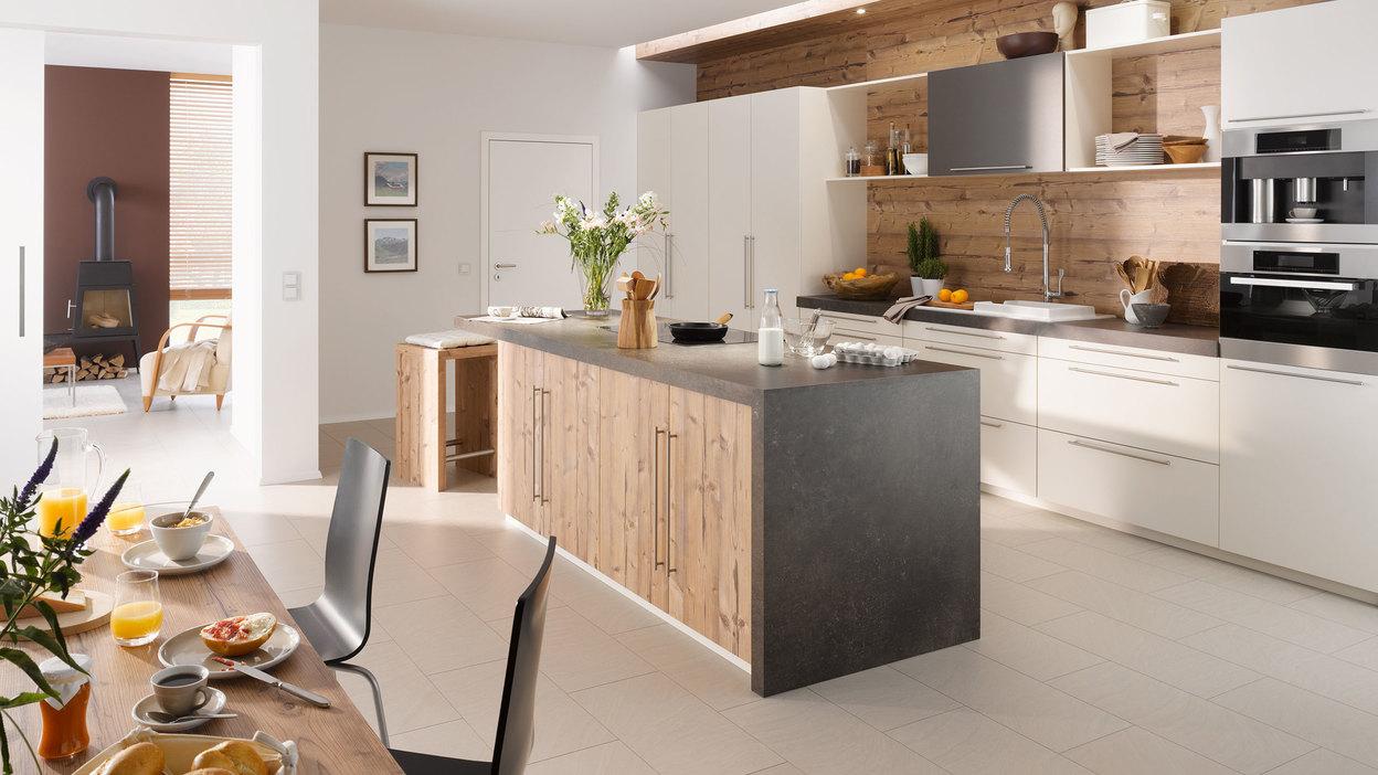 Impressionen einer Küche mit Esszimmer mit hellen Holzmöbeln und dunklen und weißen Fronten im Kontrast