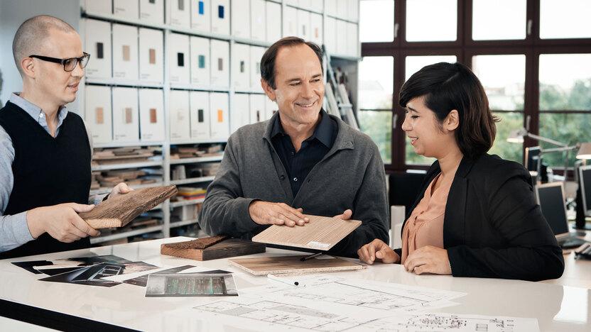 Beratung zu verschiedenen Holzoberflächen zwischen Berater und Eheleuten
